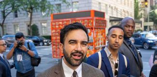 Mamdani’s Wife Exposed in Anti-Semitism Group Zohran Mamdani speaking to reporters on a city sidewalk