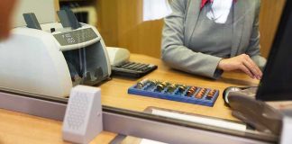 Bombshell Report Reveals Major Banks Discriminated Against Conservatives Bank teller at counter handling cash and coins
