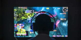 Beloved Influencer Kills Himself on Livestream Gamer wearing headphones facing a large screen