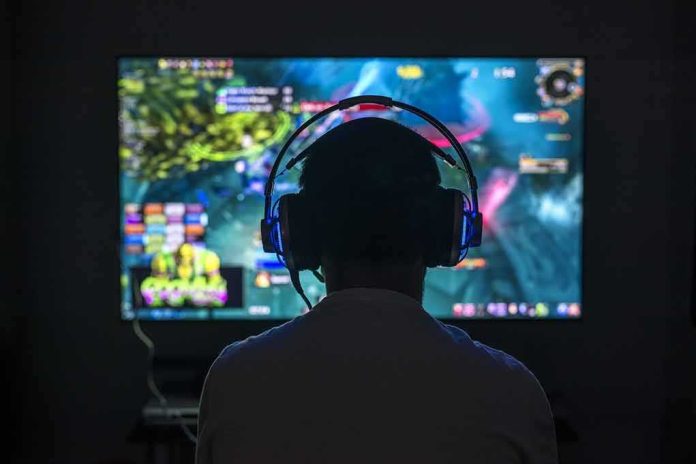shutterstock_624801452 Gamer wearing headphones facing a large screen