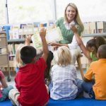 Government Lectures Grandparents on Hugging Their Grandkids ‘Without Consent’ Teacher reading to children in a library circle